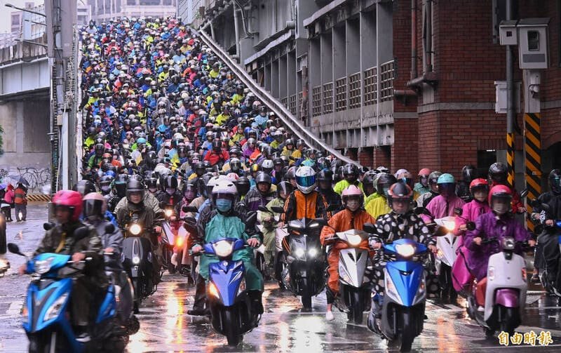 Scooter riders wearing raincoats in the rain